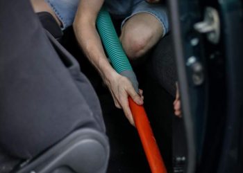 caucasian-man-vacuuming-car-gas-station