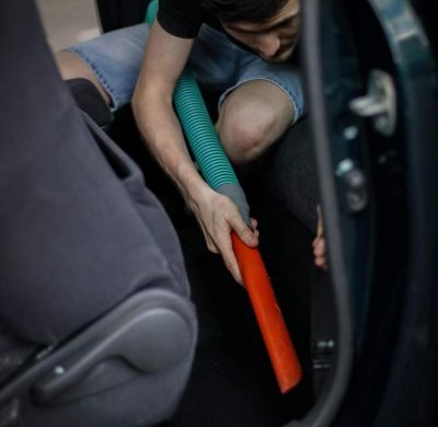 caucasian-man-vacuuming-car-gas-station