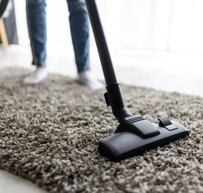 people-housework-housekeeping-concept-close-up-woman-with-legs-vacuum-cleaner-cleaning-carpet-home