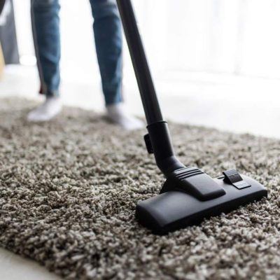 people-housework-housekeeping-concept-close-up-woman-with-legs-vacuum-cleaner-cleaning-carpet-home